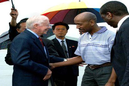 El ex presidente de EE UU Jimmy Carter saluda a Aijalon Gomes en el aeropuerto de Pyomgyang antes de volar rumbo a Boston.