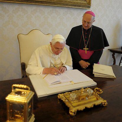 El papa Benedicto XVI firma el texto de la encíclica en su despacho del Vaticano.