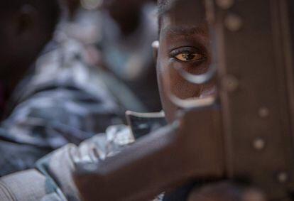 En esta foto de archivo, tomada el 7 de febrero de 2018, un soldado recién liberado observa a través del gatillo de su rifle durante una ceremonia de liberación de niños soldado en Yambio, Sudán del Sur. A la edad de 11 años, cuando Baba John huyó de la milicia a la que se había unido antes en Sudán del Sur, ya había dejado de contar la cantidad de cadáveres que había visto. Este período de asesinatos y saqueos había comenzado con una decisión difícil de tomar: matar o morir.