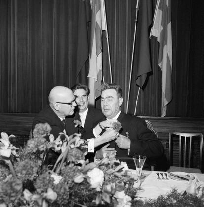 El presidente de Finlandia, Urho Kekkonen, ayuda al líder soviético Leonid Brézhnev a ponerse un clavel en la solapa durante su visita a Helsinki en septiembre de 1961.