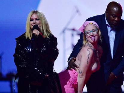 A topless demonstrator is escorted by security after she jumped onstage as Avril Lavigne spoke as the Canadian Academy of Recording Arts and Sciences (CARAS) presents its 52nd annual Juno Awards in Edmonton, Alberta, Canada March 13, 2023. REUTERS/Ed Kaiser