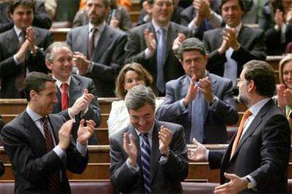Mariano Rajoy recibe los aplausos de Acebes y Zaplana tras su intervención en el pleno de aprobación del Estatut.