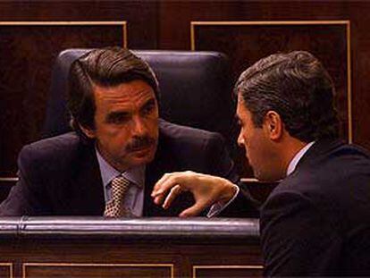 José María Aznar y el ministro del Interior, Ángel Acebes, conversan durante el pleno.