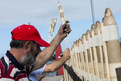 Dos hombres preparan las bombas en honor a la Virgen del Carmen en el puerto de O Grove (Pontevedra).