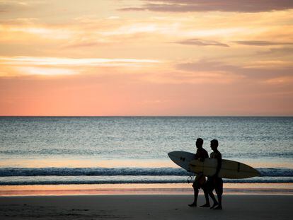 Dos surferos caminan por la Playa Avellana en Costa Rica.