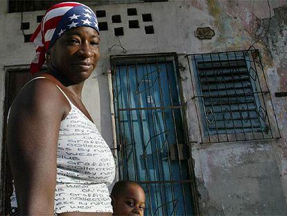 Una mujer camina con su hijo por La Habana Vieja, llevando en la cabeza un pañuelo con los colores de la bandera estadounidense.