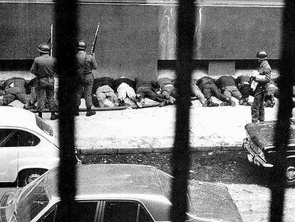 Empleados del palacio presidencial de La Moneda en Santiago de Chile son obligados a arrodillarse contra la pared en una acera tras ser detenidos por soldados leales a Pinochet el 11 de septiembre de 1973. 
Foto: Associated Press