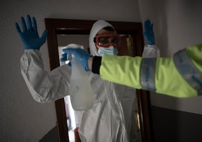 Un trabajador de una UVI móvil del Summa 112 es desinfectado tras realizar una visita, el pasado 29 de enero.
