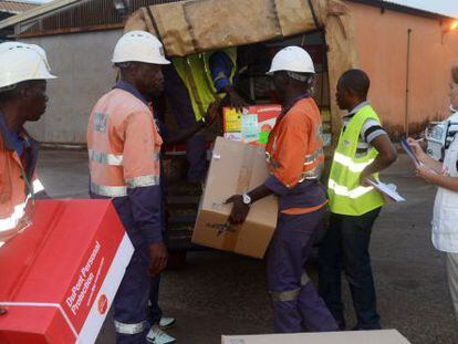 Trabajadores de M&eacute;dicos Sin Fronteras cargan material sanitario en el aeropuerto de Conakry. 