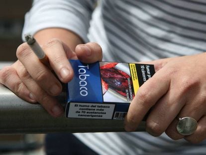 Un fumador, con un paquete de tabaco en la mano.