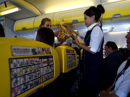 Dos azafatas de Ryanair entre el pasaje durante un vuelo.