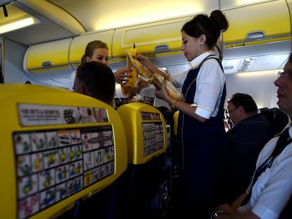 Dos azafatas de Ryanair entre el pasaje durante un vuelo.