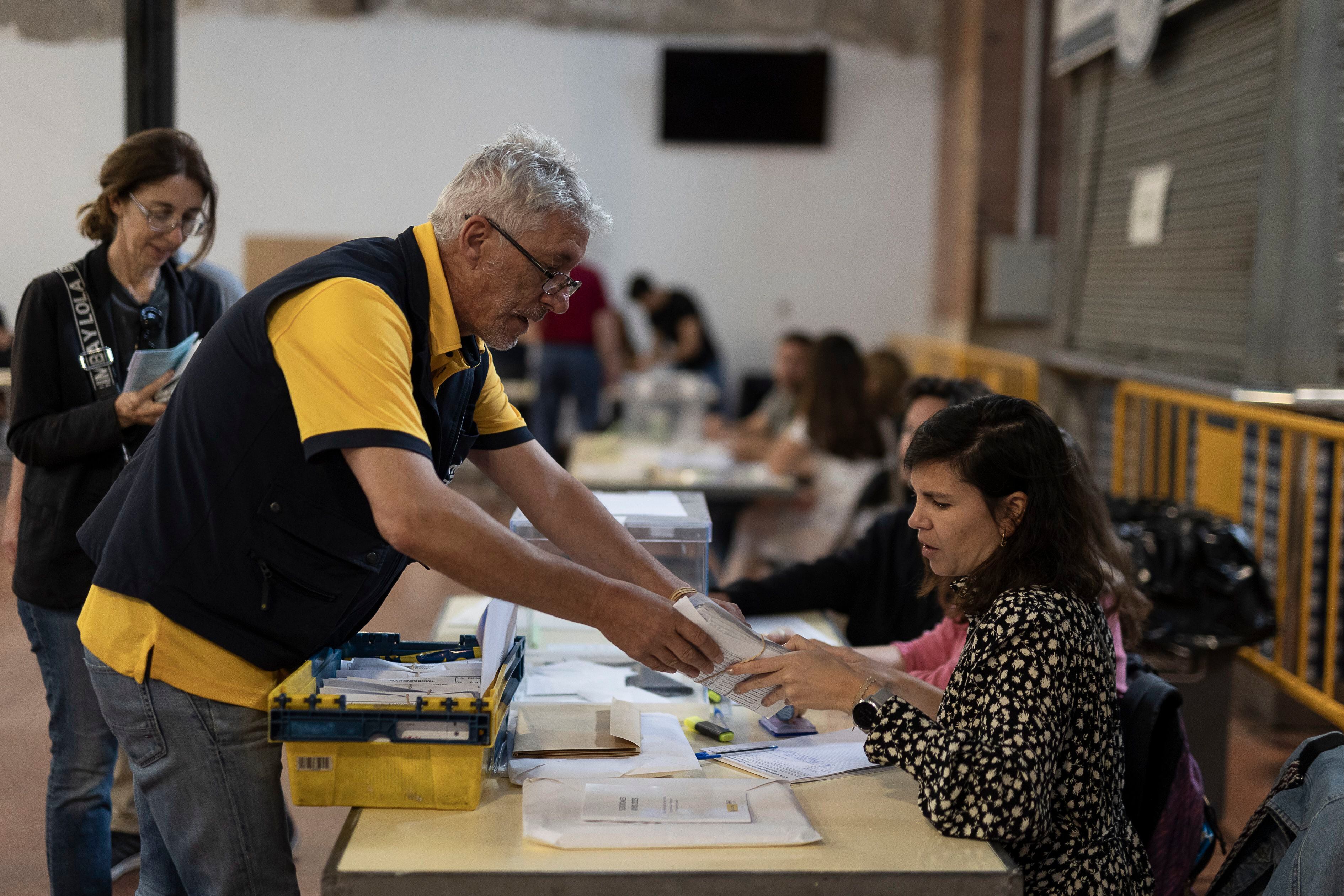 Un cartero entrega los votos por correo en una mesa electoral en el Mercat Galvany en el barrio de Sant Gervasi, en Barcelona. 