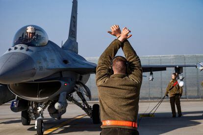 Un aviador estadounidense custodia un F-16 Fighting Falcon asignado al 480º Escuadrón de Caza, en una base aérea cerca de Fetesti, en Rumania, el 17 de febrero de 2022.