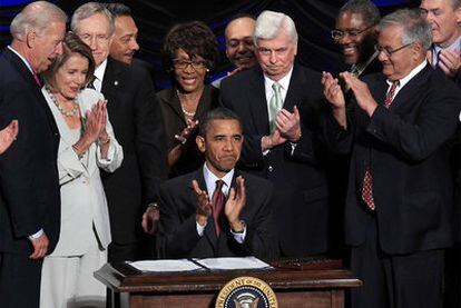 Barack Obama aplaude junto al vicepresidente Biden (izquierda) y otros altos cargos, tras firmar la reforma financiera, ayer en Washington