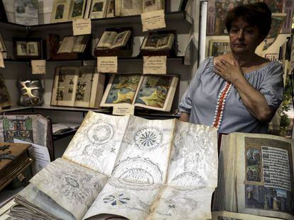 Francisca Soltero muestra un facsímil del 'Códice Voynich' en una caseta de la Feria del Libro.