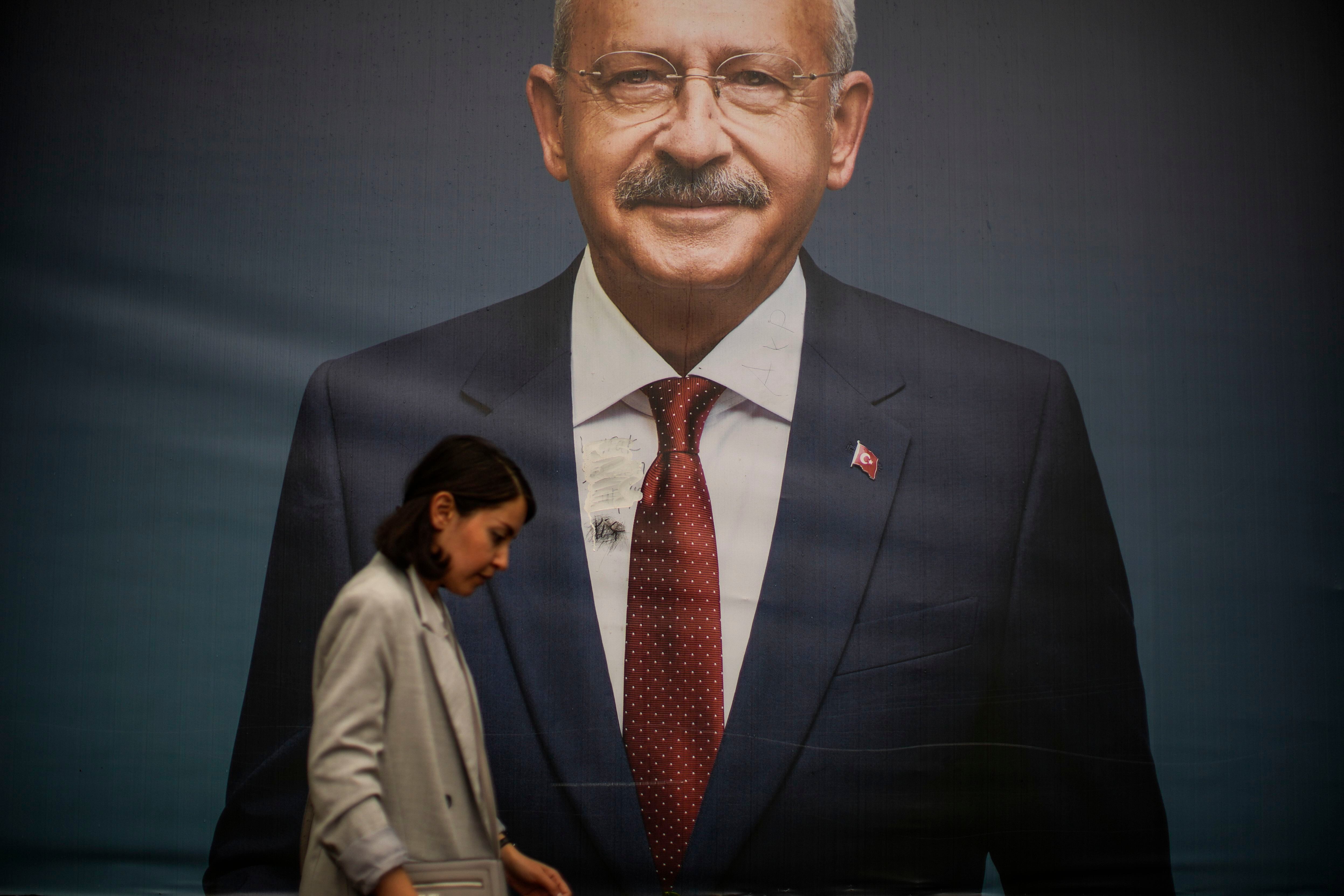 Una mujer camina junto a un cartel electoral del candidato Kiliçdaroglu en una calle de Estambul, este lunes. 