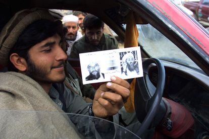 Un soldado afgano muestra uno de los miles de panfletos arrojados desde aviones militares estadounidenses, que ofrecían recompensas de hasta 25 millones de dólares por Al Zawahiri y Bin Laden, en diciembre de 2001.