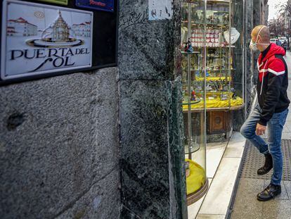 Un hombre entra en una tienda del centro de Madrid con mascarilla.