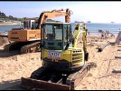 Veraneantes y excavadoras comparten sitio en la playa de El Sardinero, todavía en reparación desde el temporal de invierno