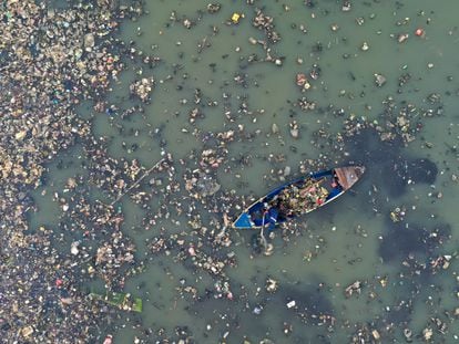 Un hombre limpiando el mar en Yakarta, Indonesia.