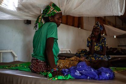 Djeuda Mussa cuida de su hija, Hadi, de un año y enferma de rubeola, en el hospital de Mora, en Camerún. Al fondo, la abuela de la niña acompaña.