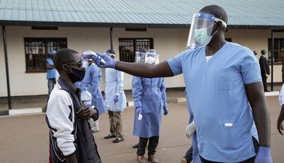 Un sanitario toma la temperatura a un ciudadano de Burundi en el campo de refugiados de Mahama en Ruanda. 