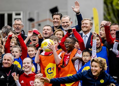 El rey Guillermo (tercero por la derecha en la última fila) y el rey Felipe VI (cuarto por la derecha, en la última fila) posan con niños durante su visita a una tarde deportiva de la Fundación Cruyff en Ámsterdam.