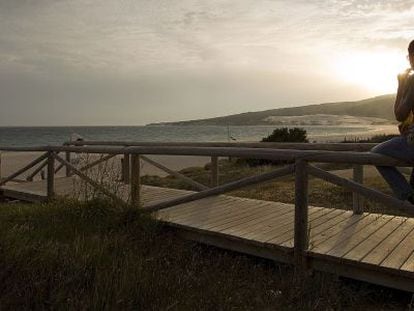 Un joven observa la puesta de sol en una playa de Tarifa.