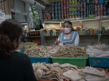 Una vendedora atiende un cliente en un mercado en Toluca, en el Estado de México.