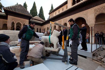 Los operarios trabajan en la colocación del primero de los leones en la Alhambra.