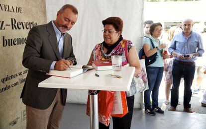 El escritor Arturo Perez Reverte firma ejemplares de su novela 'Hombres buenos', el 31 de mayo de 2015.