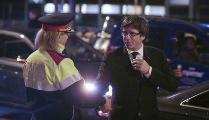 El presidente de la Generalitat, Carles Puigdemont, saluda a una agente de los Mossos de Esquadra. 