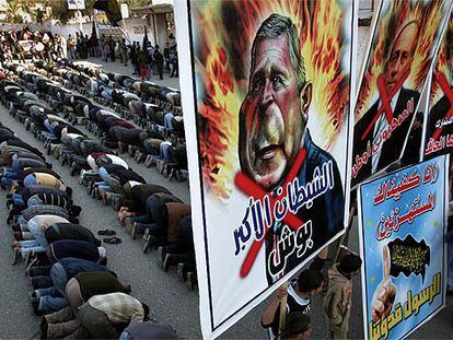 Militantes de Yihad Islámica rezan detrás de carteles contra Bush, el primer ministro interino de Israel, Ehud Olmert, y Rasmussen.