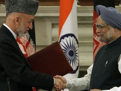 Hamid Karzai y Manmohan Singh se saludan tras firmar el acuerdo bilateral.