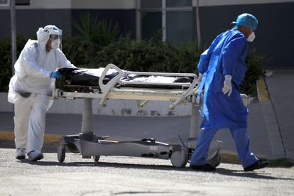 Personal médico traslada el cuerpo de un fallecido por covid-19 hoy en el Hospital General en Ciudad Juárez (México).