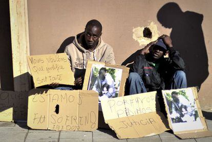 Un grupo de subsaharianos exhibe fotos del senegalés muerto y muestra carteles reclamando justicia en el lugar en que se cometió el crimen.