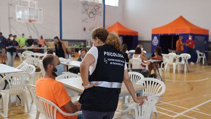 La psicóloga Alicia Doña asiste a uno de los 1.600 evacuados en el incendio de Sierra Bermeja (Málaga), acogidos en un pabellón de Ronda