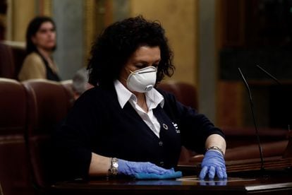 Una ujier desinfecta un atril en el Congreso de los Diputados, en marzo de 2020.