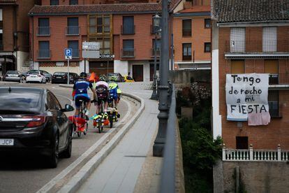 Un grupo de ciclistas atraviesa el puente de entrada a Tordesillas, que cruza el río Duero, donde lleva meses colgado un cartel en defensa del Toro de la Vega.