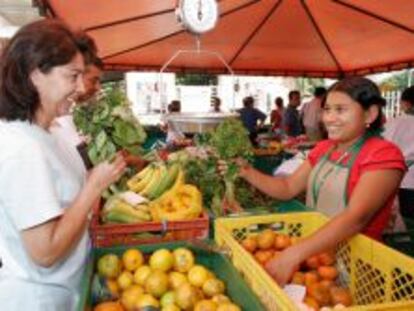 Se&ntilde;ora comprando fruta en el puesto de un mercadillo