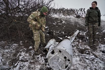 Vira, de 39 años (a la derecha), junto a los restos del misil derribado el viernes en Kiev.