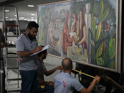 Operarios revisan el cuadro del pintor brasileño Di Cavalcanti tras ser dañado por los golpistas que asaltaron la sede de la Presidencia.