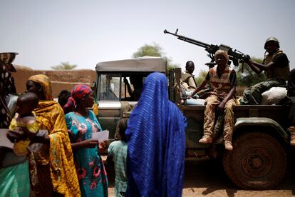 Soldados del ejército de Malí pasan junto a un grupo de mujeres y niños durante una operación en Nadki el 29 de julio de 2019.
