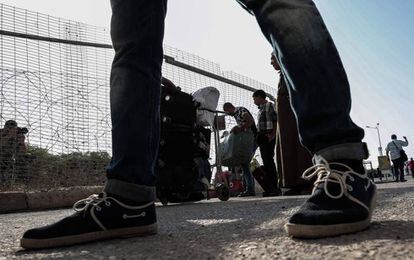 Un grupo de palestinos espera para recibir permisos y cruzar a Egipto. 