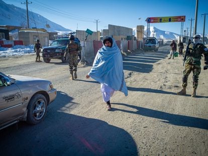 Taliban fighters check vehicles and passengers at a security checkpoint on the road to Wardak province, at the western gate on January 14, 2022