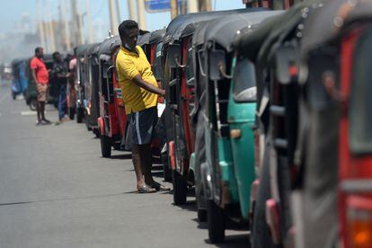 Varios rickshaws esperan en una larga cola para llenar combustible en una gasolinera en Colombo. 