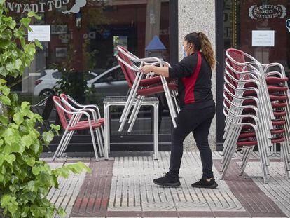 Una camarera prepara la terraza de una cervecería, en Navarra.