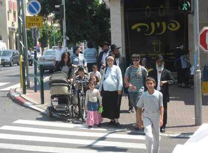 Familias ultraortodoxas judías transitan al lado de la tienda sólo para mujeres, en Bnei Bank.