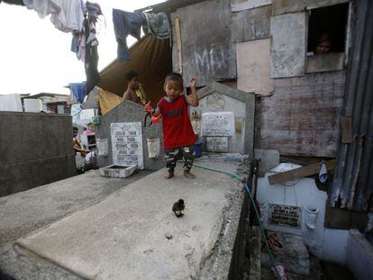 Muchos cementerios públicos en Metro Manila son el hogar de miles de filipinos que comparten espacio con los muertos. En la foto, un niño camina sobre una tumba del cementerio público de Pasay City, al sur de Manila.